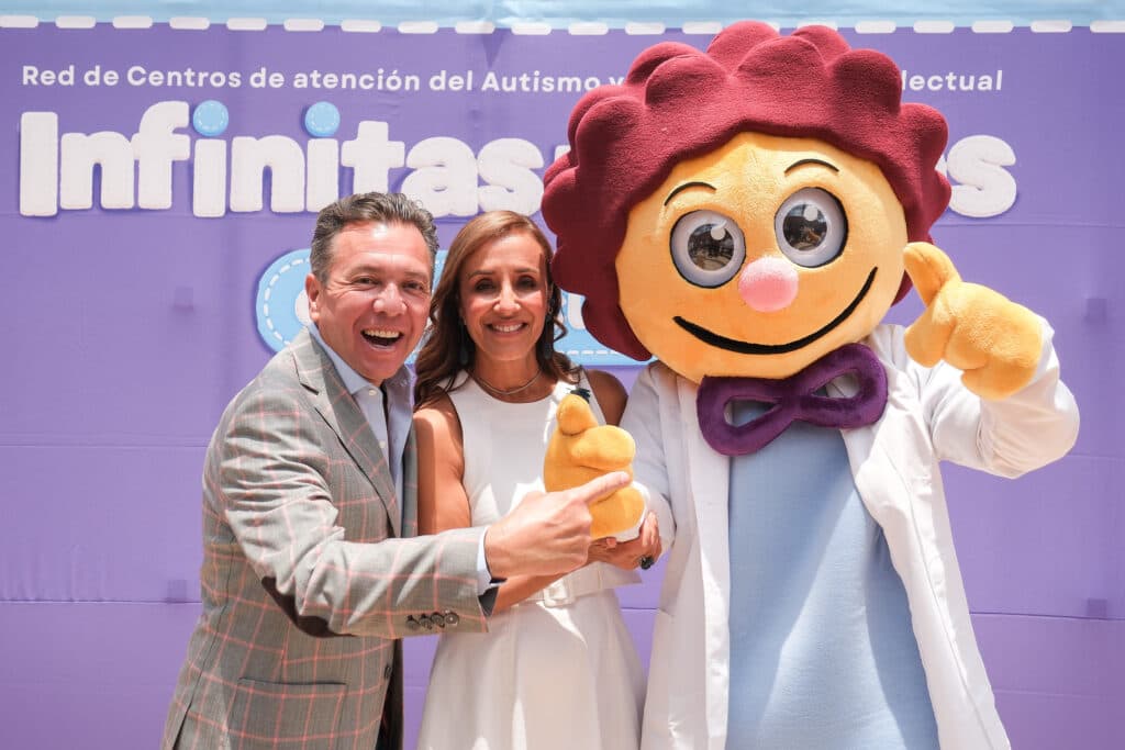 Pablo Lemus Navarro y una mujer sonriente posan junto a un personaje de caricatura en la inauguración de un centro de autismo en Tepatitlán.
