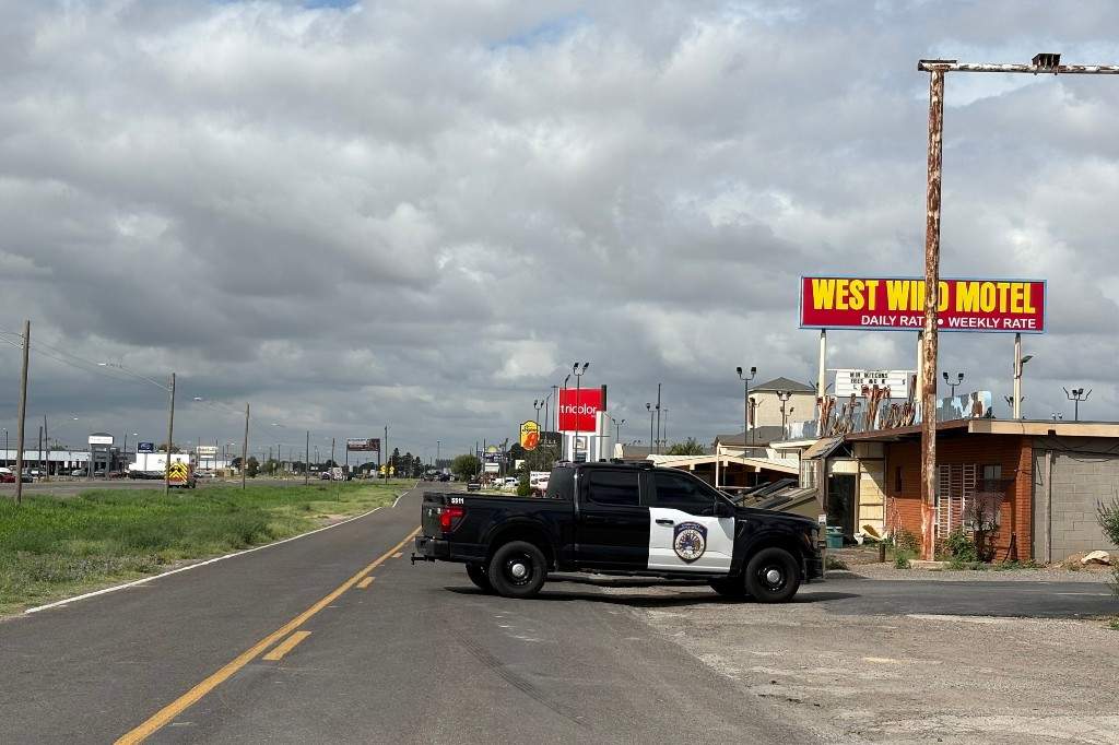 Vehículo policial bloqueando la carretera cerca del West Wind Motel en Midland, Texas, tras el tiroteo que dejó un muerto y varios heridos.