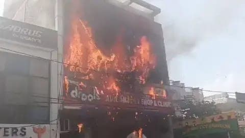 Incendio devastador en un edificio de tres niveles en Lucknow, India, con llamas que consumen la fachada del instituto educativo.