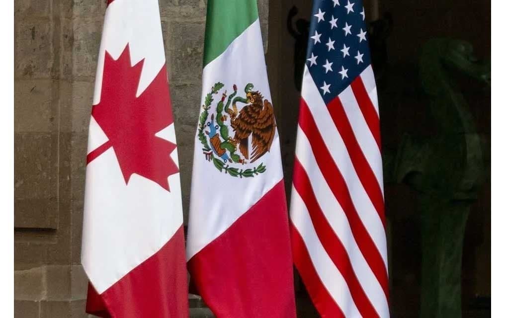 Banderas de México, Estados Unidos y Canadá ondeando, simbolizando la negociación del T-MEC en Washington.