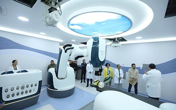Sala de tratamiento del IMSS con tecnología avanzada para el tratamiento de cáncer ocular, médicos y pacientes presentes.