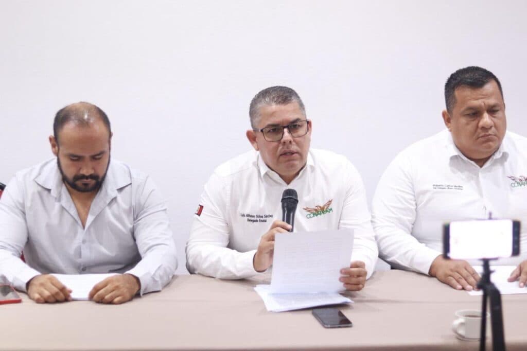 Luis Alfonso Ochoa Sánchez, representante de transportistas, habla en conferencia sobre adeudos de Fertinal-Pemex, acompañado de otros líderes.
