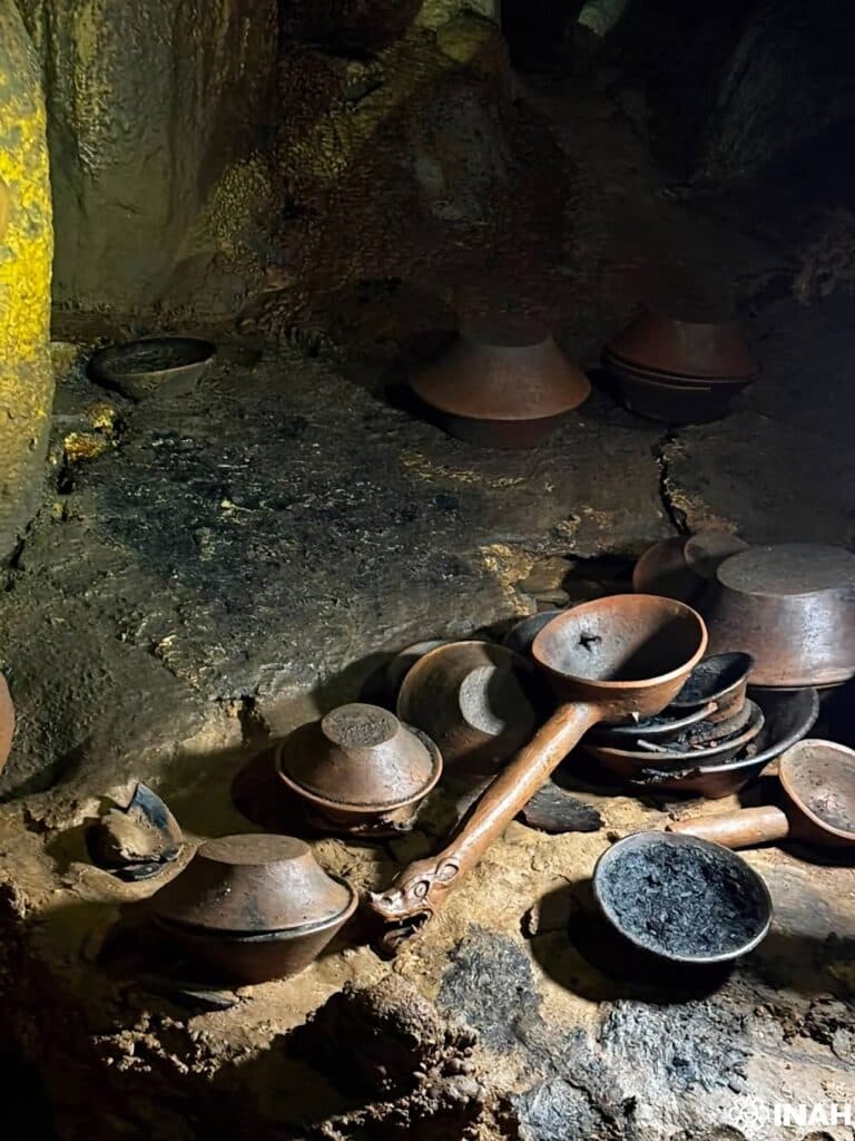 Recipientes cerámicos y fragmentos de vasijas descubiertos en una cueva de Cintalapa, Chiapas, revelando hallazgos arqueológicos prehispánicos.