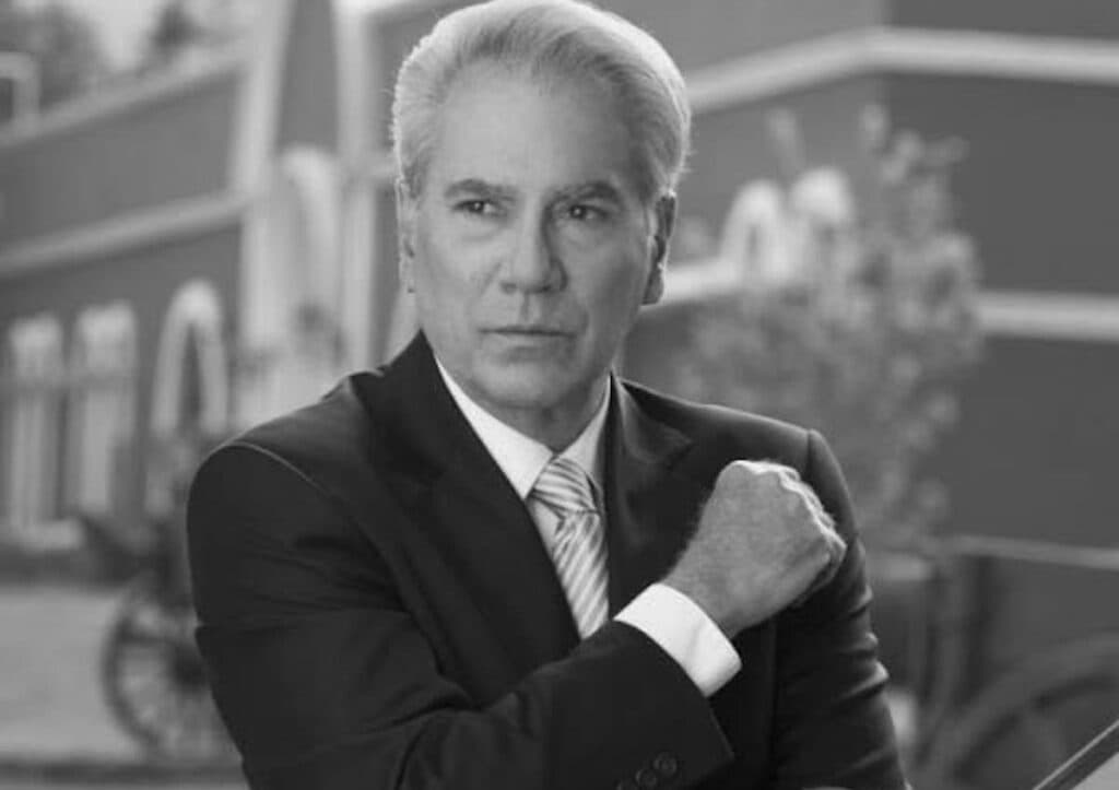 Otto Sirgo en un retrato en blanco y negro, luciendo un traje y con una expresión seria, recordado por su legado en la televisión mexicana.
