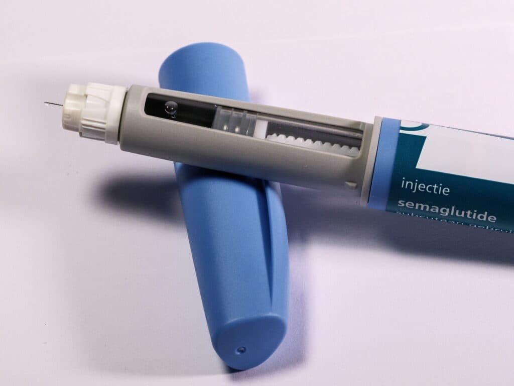 Pluma de medicamento para inyección de semaglutida, utilizada en tratamientos para el control de peso, sobre fondo blanco.