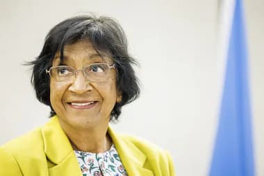 Navi Pillay sonríe durante una conferencia, destacando su compromiso con los derechos humanos y la justicia internacional.