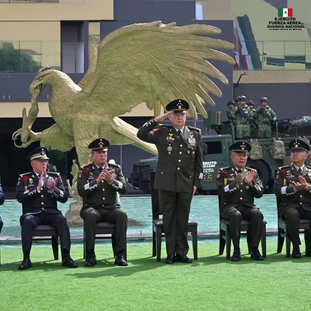 Ceremonia del 205 aniversario de la Sedena, con el general Trevilla en el centro, saludando frente a un águila monumental y otros altos mandos.