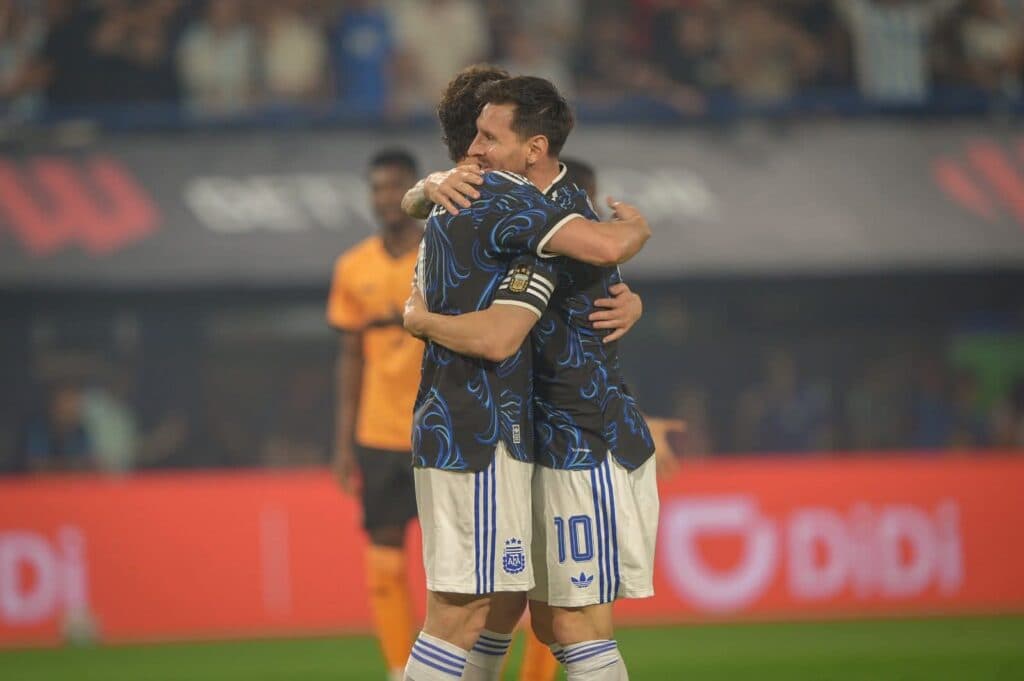 Jugadores de la Selección Argentina se abrazan en un momento emotivo durante un partido, resaltando la camaradería del equipo.