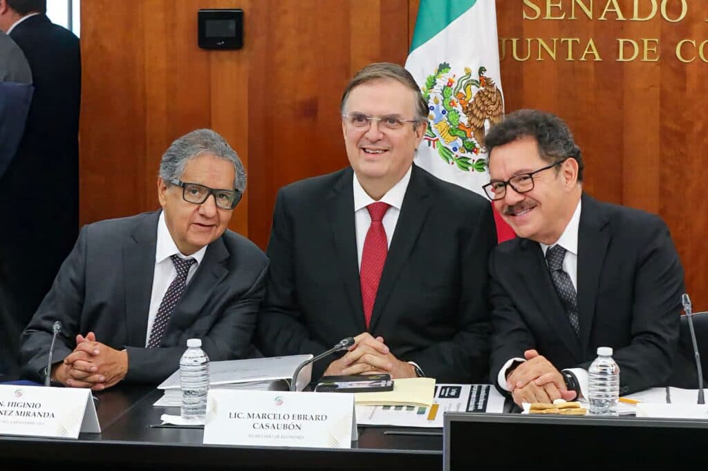 Marcelo Ebrard, secretario de Economía, sonríe junto a legisladores en el Senado, discutiendo la revisión del T-MEC.