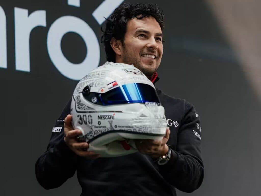 Sergio Checo Pérez sostiene su casco especial con símbolos mexicanos y el número 300, en la presentación en Plaza Carso, Ciudad de México.