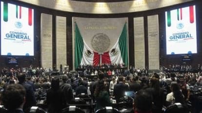 Sesión en la Cámara de Diputados donde se aprobó la reforma para sancionar el reclutamiento criminal, con banderas de México de fondo.