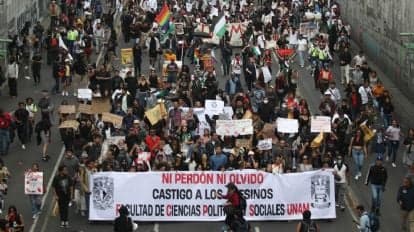 Cientos de manifestantes marchan en CDMX con pancartas y consignas, exigiendo justicia por la represión estudiantil de 1968.