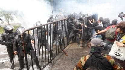 Enfrentamiento entre policías y manifestantes durante protesta por la calidad del agua en Guadalajara, Jalisco, con uso de gas lacrimógeno.